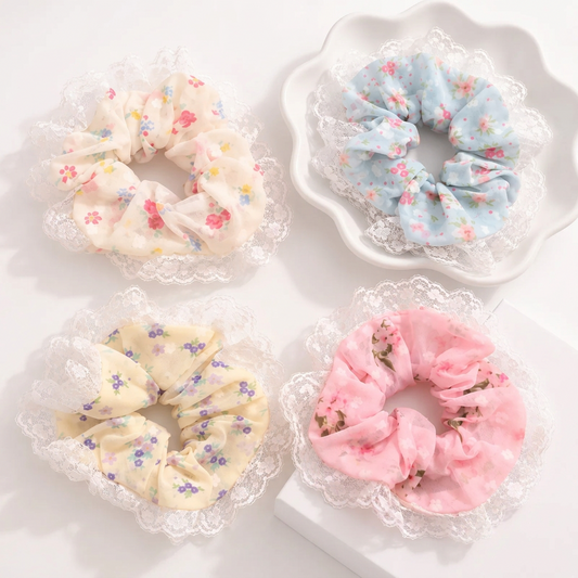 Cute floral scrunchies in pastel pink, blue, yellow and cream with delicate white lace ruffles.