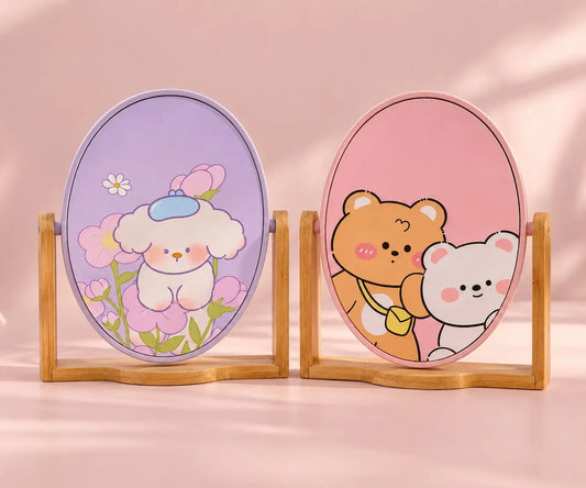 Kawaii oval tabletop mirrors with cute pastel character designs and wooden stands on a soft pink background.