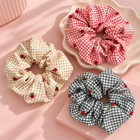 Cherry gingham hair scrunchies in red, beige and black checkered patterns with cute cherry prints and fluffy ruffled fabric.
