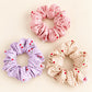 Cute cherry polka dot hair scrunchies in pastel pink, purple and cream with soft ruffled fabric.