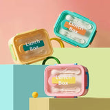  Pastel bento lunch box with transparent lid, built-in cutlery, carry handle, and secure side locks.