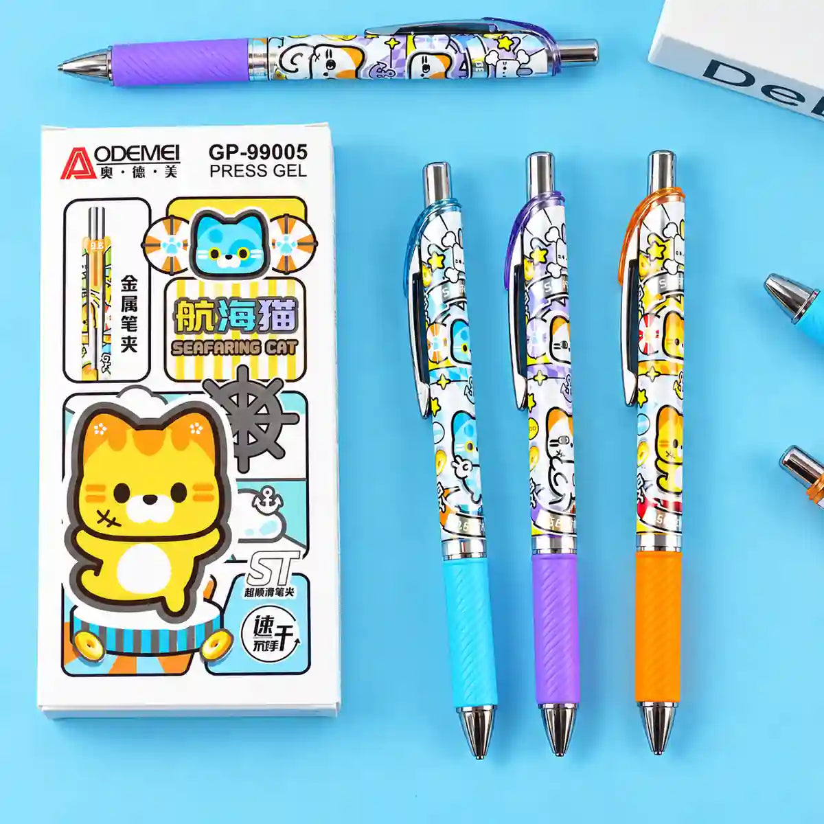 Three Aodeei press gel pens with colorful cartoon cat designs are displayed next to their retail packaging box on a light blue background.